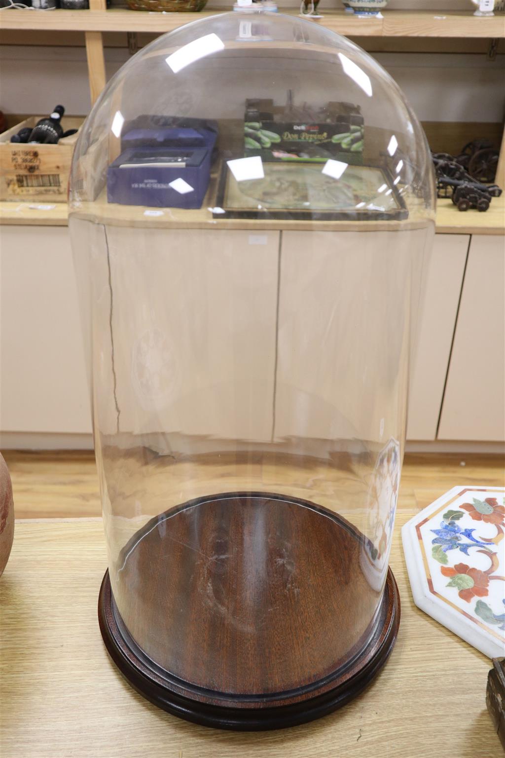 A glass dome on stand, overall 60cm